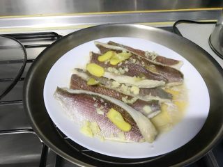 5、馋嘴版家庭烤鱼,蒸好的鱼，把姜片取下来，汤可以倒掉。