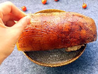 5、梅菜扣肉,趁着猪肉煮好后还热,将老抽均匀涂抹在猪皮上,用牙签在猪皮上扎眼孔,使得猪皮容易上色,将猪肉静放10多分钟(猪皮朝上),晾干猪皮上的酱油,减少下一步炸肉皮油贱飞伤到手。
