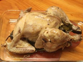 13、茄苳蒜头鸡,移开叶子，全鸡上桌。。鸡肉本身虽然经过烘烤，但也煮的软烂多汁，鸡肉的甜味带着蒜头和茄苳及麻油的香气，风味十足。