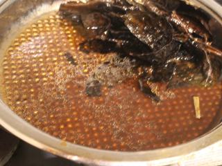 14、茄苳蒜头鸡,锅底的汤汁，是麻油、茄冬和鸡汁精华，可以再淋在鸡身上，也可以沾着鸡肉吃。淋饭也是很美味。