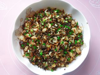 12、梅干菜麦饼,炒匀后盛出，加入香葱拌匀，晾凉待用。