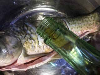 3、麻辣火锅鲜鱼,市场买回斩杀好的鱼,洗净后鱼身两面各切三刀,放入料酒,放入一勺盐,鱼肚里鱼身抹均匀