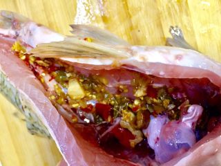 4、麻辣火锅鲜鱼,在鱼肚里装入半勺泡椒末