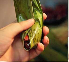 8、红豆肉粽,将粽叶往一个方向叠去，完全包裹糯米