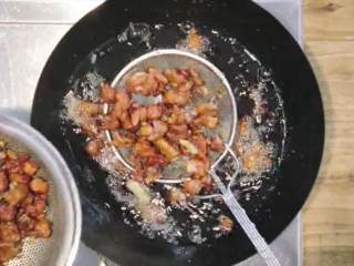 11、川香辣子鸡,倒入姜片翻搅，再次捞出油锅中的鸡肉块