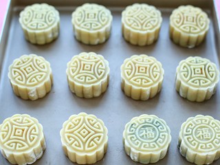 21、广式蛋黄莲蓉月饼,将做好的月饼排放烤盘内,表面喷少许的清水防干