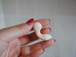 15、蜗牛马卡龙,翻糖取出手捏成蜗牛身子形状，尾部压扁在碟子上，搓两个圆球当眼球，竹炭粉染黑当小眼珠，翻糖花支杆插进去头部，蔓越莓粉加入翻糖捏成小舌头即可装饰