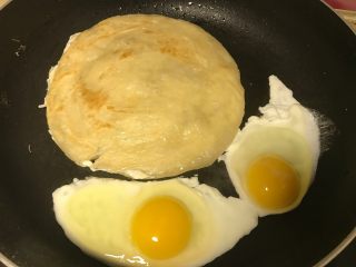 2、里脊蛋手抓饼,一面基本熟了翻面，同时在一旁加适量油打入鸡蛋。