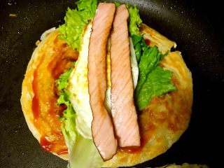 5、里脊蛋手抓饼,依次放入生菜煎蛋和里脊肠。