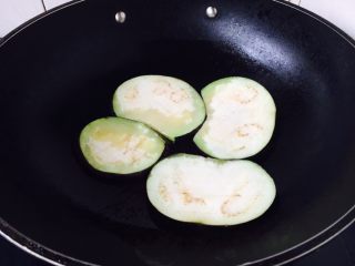 7、#咸味#  家乡特色茄子饭,起锅锅热放入50g的油，中火，放入茄子片，每片每面煎制约2分钟左右。