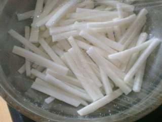 3、自制(爽口咸萝卜条),用保鲜膜封上，放入冰箱冷藏腌制一宿入味儿；