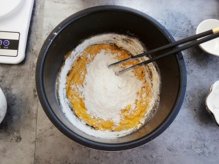 6、奶香小星星南瓜馒头,慢慢倒入面粉,一边到一边用筷子进行搅拌,直到呈柳絮状