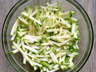 2、西葫芦早餐饼,加入1茶匙盐拌匀，静置15分钟以上，使西葫芦丝软化、析出水分。