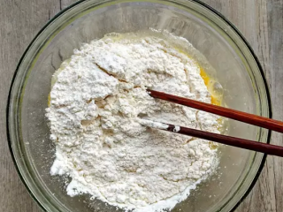 4、西葫芦早餐饼,鸡蛋磕入碗中，加入少许盐和黑胡椒粉（最后蘸酱吃的话，可以少放），再倒入一杯面粉。