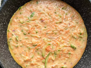 8、西葫芦早餐饼,加热平底锅，注入少许油，倒入面糊，晃一晃锅身摊开，中小火慢煎。这份面糊可以摊出三个大饼。PS:面糊不要太厚，倒入稍薄的一层摊开就好。我个人觉得我的蛋饼都摊厚了，摊薄一点水分挥发的会更好。