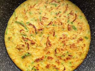 9、西葫芦早餐饼,一面煎至凝固焦黄，晃一晃锅身能蛋饼脱离锅底，翻面继续煎熟既可出锅啦！