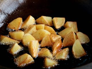 8、『土豆茄子煲』,锅内倒入色拉油，油热后倒入土豆炸至金黄色