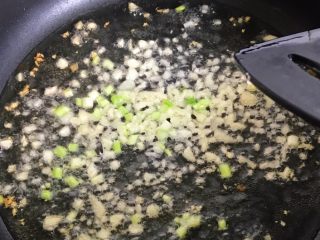 7、酱盖面,把蒜末和葱白下油锅爆炒至香味溢出
