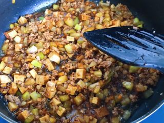 12、酱盖面,倒入酱汁翻炒