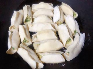7、冬至美食+韭菜猪肉锅贴,锅中倒入底油加热摆入锅贴中火煎起来