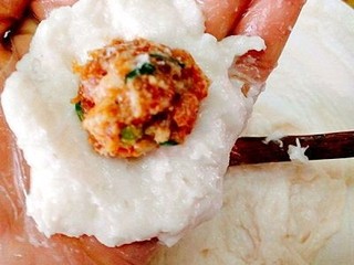 14、福州+Q弹包心鱼丸,盛一勺鱼肉蓉在手掌上摊开，中间放一块馅料，
