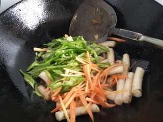 7、炒年糕,再加入胡萝卜丝和青椒丝