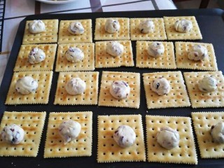 9、蔓越莓牛轧饼干,揉成12~15克的圆剂子，放在饼干上面。