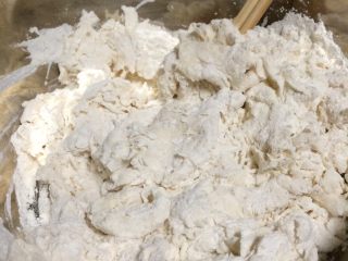 4、美味羊肉包子,一边搅拌一边缓慢加入牛奶水，搅拌成面絮