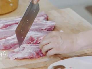 2、玫瑰叉烧煲仔饭,将梅花肉切成条，用刀切断肉筋