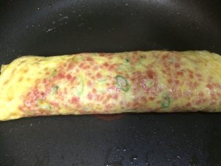 14、火腿葱花厚蛋烧,全部卷好之后放在锅中煎,两面再煎1分钟至熟