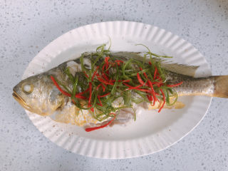12、清蒸黄鱼,蒸熟后，倒掉盘中的液体，放上葱丝和辣椒丝。