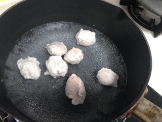 6、Q弹劲道的山药肉丸子,用勺子挖出一个肉丸放入锅里,这时候需要把火力调到最小。