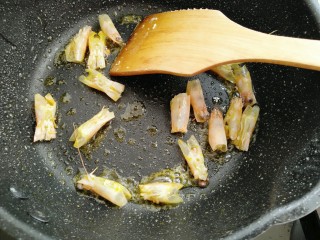 10、鲜虾滑蛋炒碗豆,锅中放油放入虾头炒香