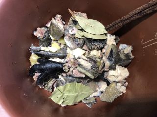 4、冬日滋补汤|姬松茸炖乌鸡,捞出鸡肉，煮过鸡肉的水就不要了，把鸡肉放到紫砂锅里，放入三片香叶，1小块姜，一个砂仁