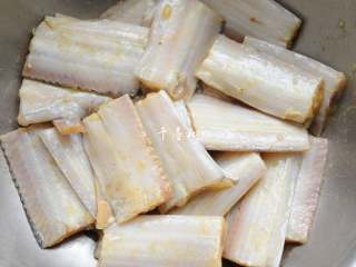 6、红烧带鱼最经典最家常的做法 可当热菜也可是冷盘 味道都一样好,用手抓，把鸡蛋抓散开抓匀，加鸡蛋的原因一是要炸出来的颜色更加金黄漂亮，二是可以在炸制的时候防止油星到处飞溅。抓匀后腌制15分钟。