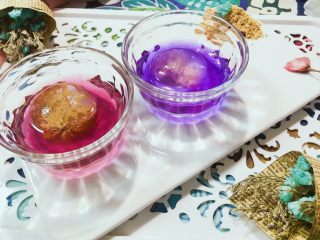 20、佳儿的水信玄饼●少女心怦怦滴,我们之前准备的黑枸杞,用热水冲泡之后。会呈现紫色的茶汁,冷却后,调上蜂蜜,可以这样和玄饼搭配,超级好看吧?至于那个玫瑰色的茶汁,也是黑枸杞水,只不过加了几滴柠檬汁,就变红了,神奇吧?