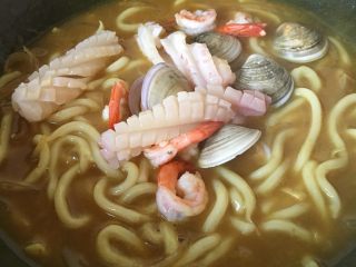 18、咖喱海鲜乌冬面,放入鱿鱼、文蛤和虾大火煮半分钟