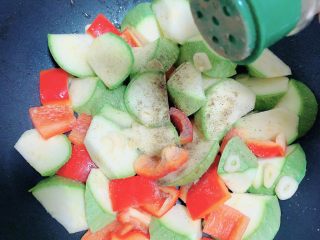 12、照烧鸡胸蔬菜酿皮,加入盐、黑胡椒粉,中火煎烧。