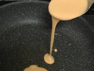 5、胡萝卜小饼,热锅刷油，开小火，舀一勺面糊，自上而下倒入，面糊自动成圆形。待定形