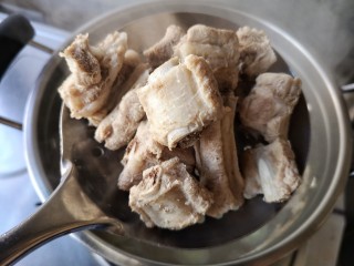 8、酸菜排骨暖锅,将煮好的排骨沥水捞出,煮排的汤沥出作料后,备用。