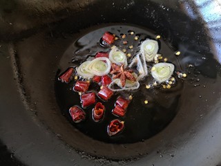 10、酸菜排骨暖锅,锅中适量油烧热,放葱花、干辣椒和八角煸香。