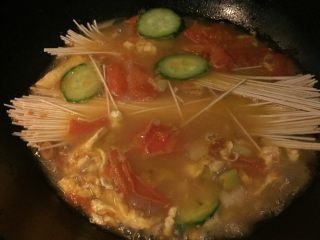 6、西红柿鸡汤面,如图加入黄瓜片和面条（手擀面，挂面均可）盖上锅盖大火烧开，转小火煮10_15分钟，根据苗条的粗细决定时间。