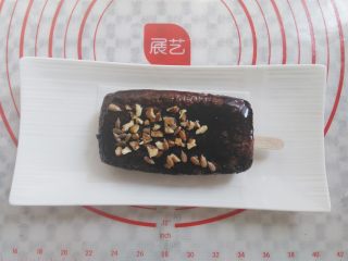 19、冰淇淋小蛋糕,在裹好酱的蛋糕上撒上适量的坚果粒，为了方便拿，我在蛋糕胚下面垫了一张小的油纸