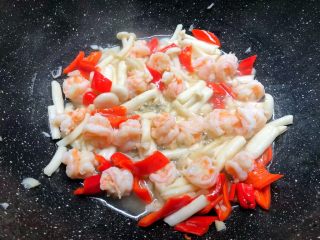 6、虾仁炒西兰花,加入蒜末炒出香味，再加入海鲜菇煸炒1分钟，加入红辣椒炒至断生。