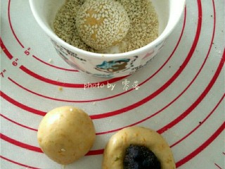 8、南瓜豆沙丸子,搓好的圆子按扁，抱入豆沙丸子，收口，滚圆，裹一层白芝麻；