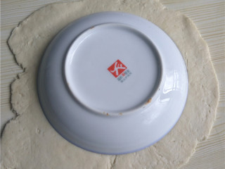 8、玉米煎饼,将面团擀成均匀厚薄的面片；饭碗倒扣，压出圆形面片；