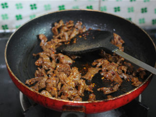11、孜然羊肉,放入辣椒粉、孜然粉、花椒粉翻炒均匀