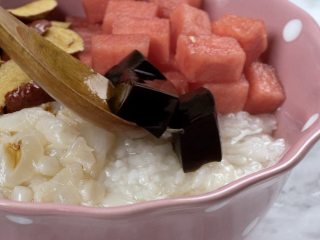 5、消暑仙草水果冰粥,碗中放入熟糯米、荔枝肉、西瓜块、红枣粒、仙草冻100g、葡萄干、花生米