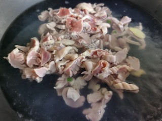 7、辣炒鸡胗,锅里放水烧开,放入姜片,倒入一勺料酒,然后将鸡胗放入焯水约一分钟,变色后捞出。