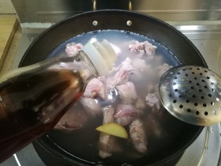 6、红烧小羊肉,倒入小羊肉、大块姜片并倒入料酒。